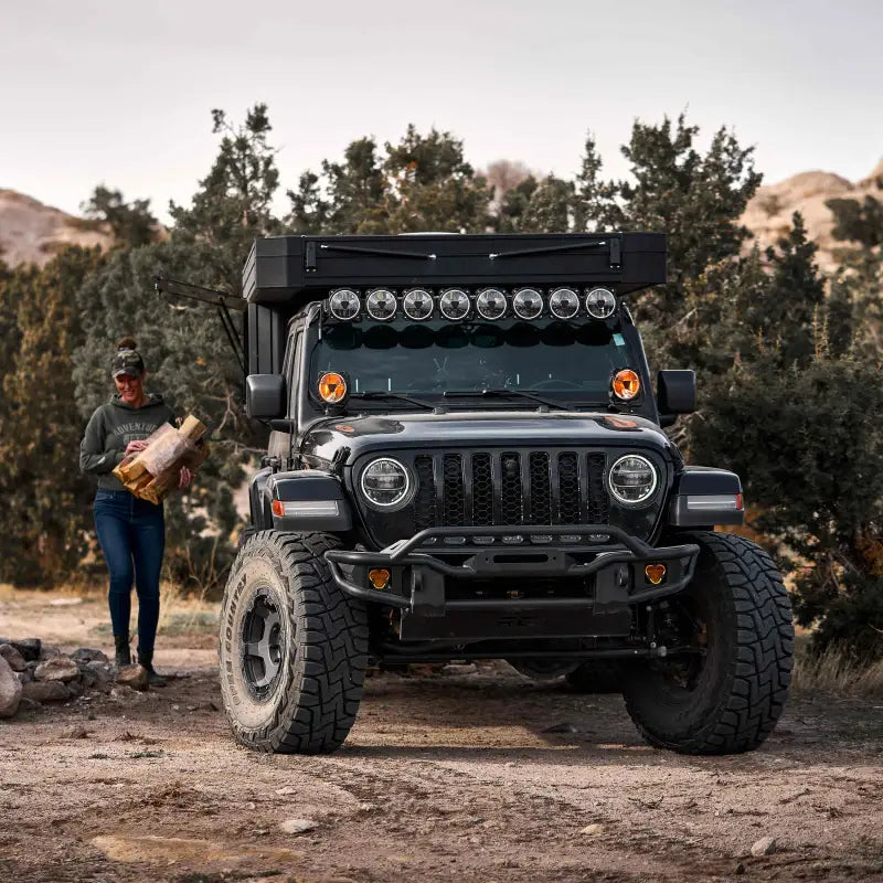 Black off-road vehicle with Gravity® Titan™ 6-inch LED lights, parked in rugged terrain, emphasizing their durability and performance.