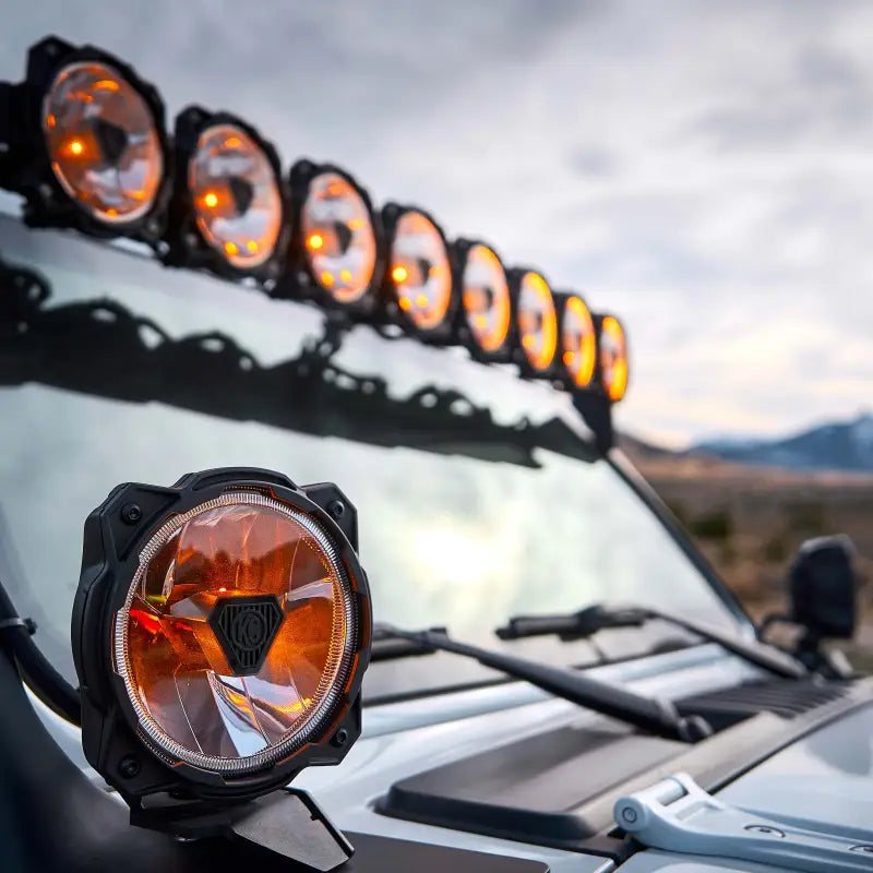 Amber-lit Gravity® Titan™ 6-inch LED off-road lights mounted on a vehicle, providing wide-range visibility for off-road adventures.