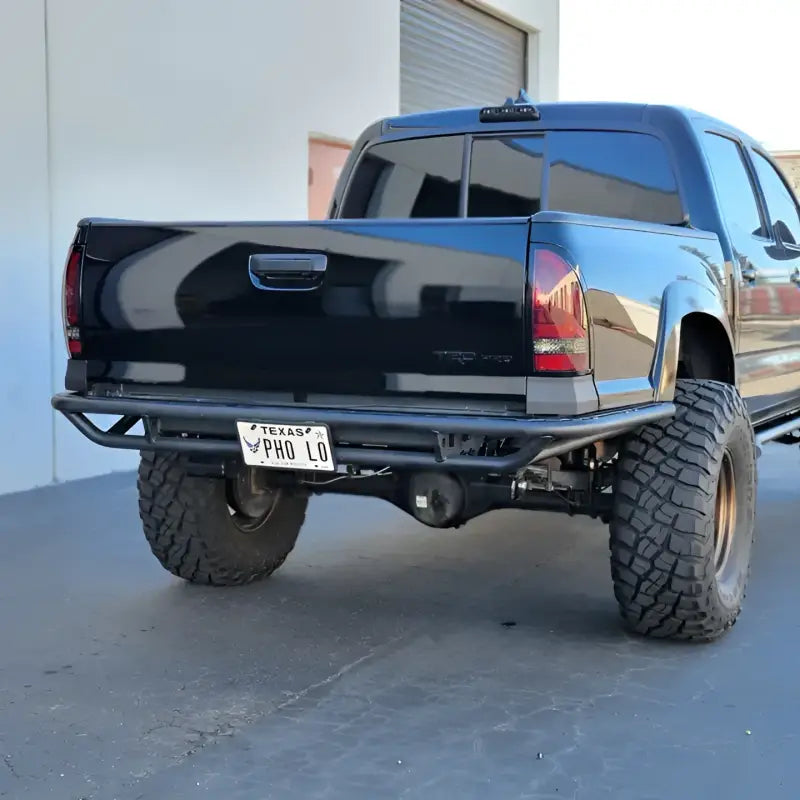 Rear view of a Toyota Tacoma featuring the 2005-2015 HC Rear Tube Bumper with durable construction, high clearance, and off-road compatibility.