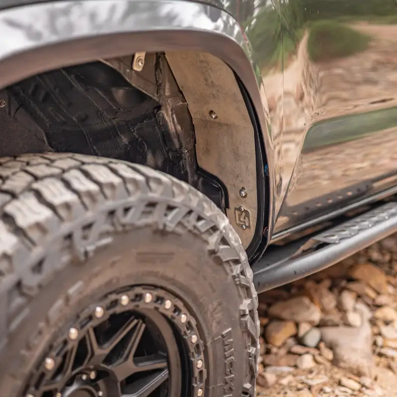 High clearance bolt-in aluminum fender liner installed on a 3rd Gen Tacoma, showcasing maximum tire clearance and door jam coverage.