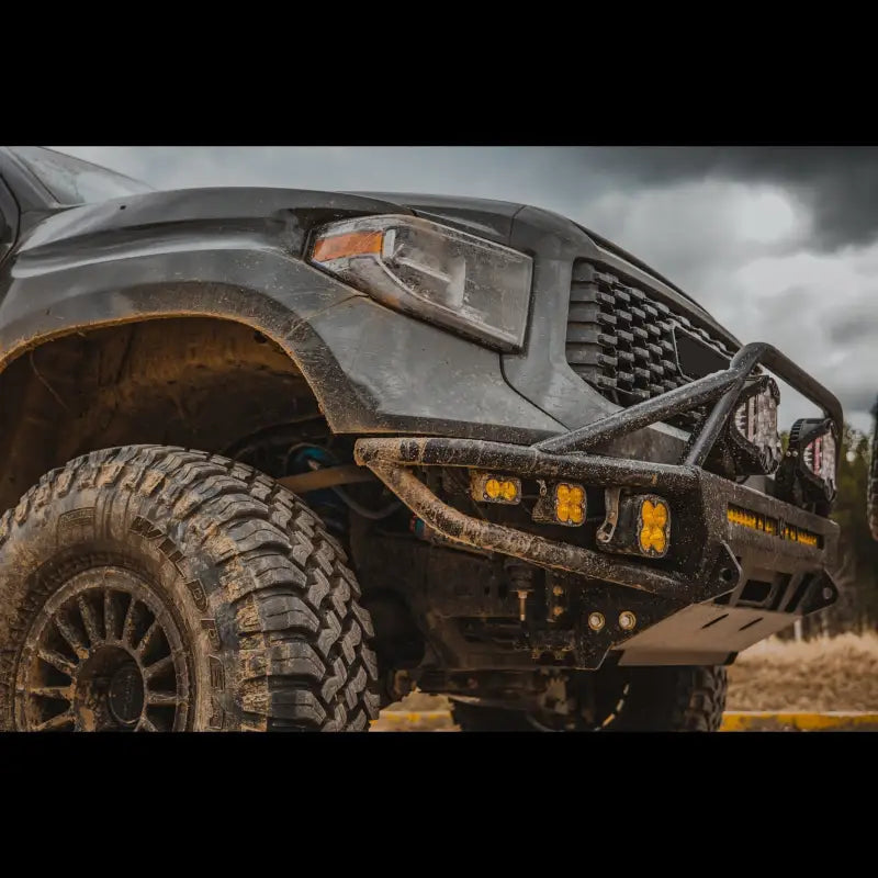 Close-up of black Toyota Tundra with hybrid front bumper, LED lights, and off-road tires, designed for 2014-2021 models.