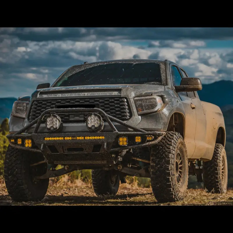 Toyota Tundra with hybrid front bumper, LED lights, and off-road tires, designed for 2014-2021 models, parked in a rugged outdoor setting.