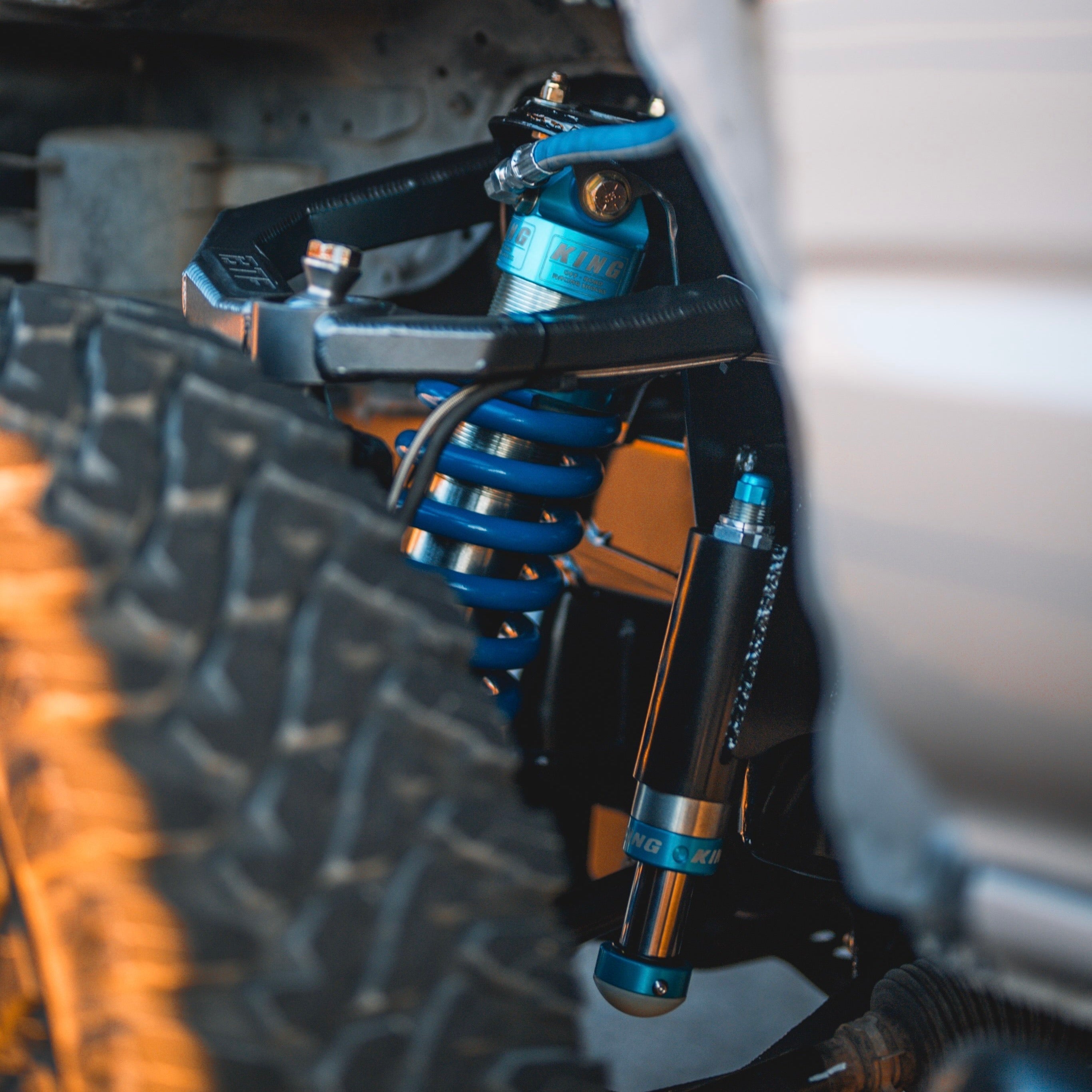 Close-up of blue coil-over shocks and suspension components on a 5th Gen 4runner / GX460, designed for off-road durability.