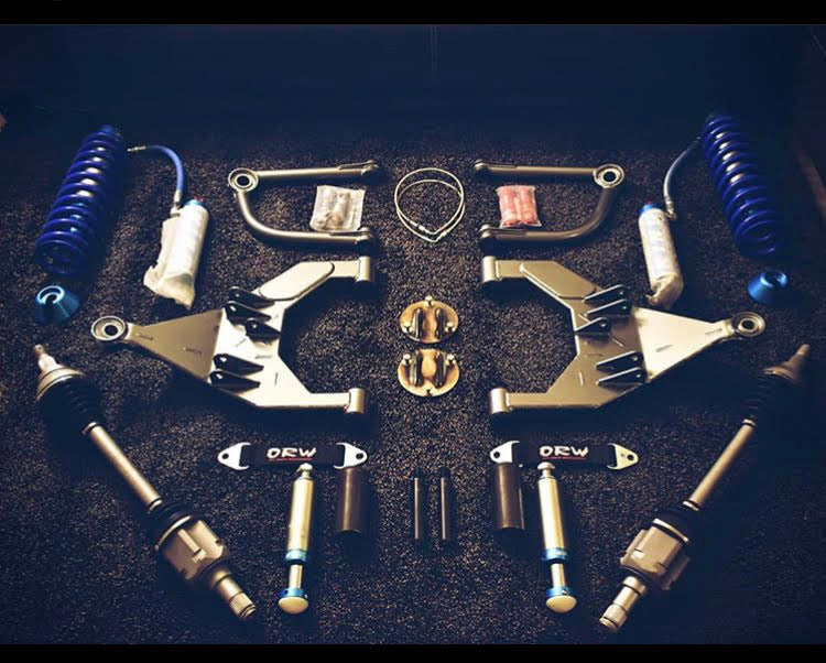 Complete 5th Gen 4runner / GX460 long travel suspension kit laid out, including control arms, shocks, and coil springs.