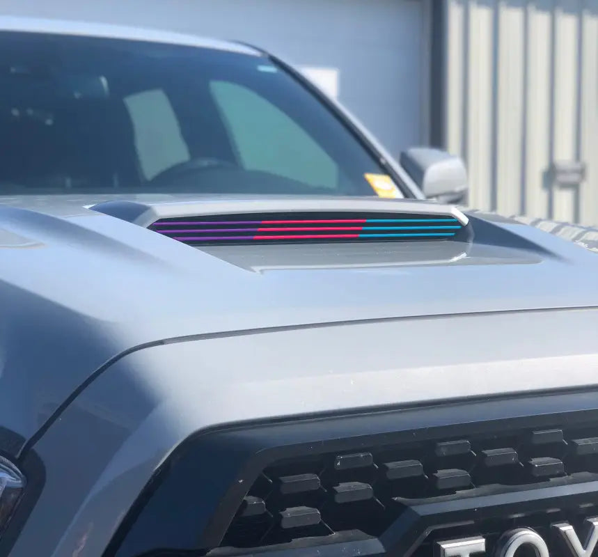 Multicolor inner hood scoop line accents in purple, red, and blue installed on a Toyota Tacoma, offering a unique aesthetic.