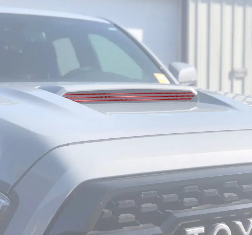 Red inner hood scoop line accents installed on a 2016-2023 Toyota Tacoma, enhancing the vehicle's exterior with a sleek design.