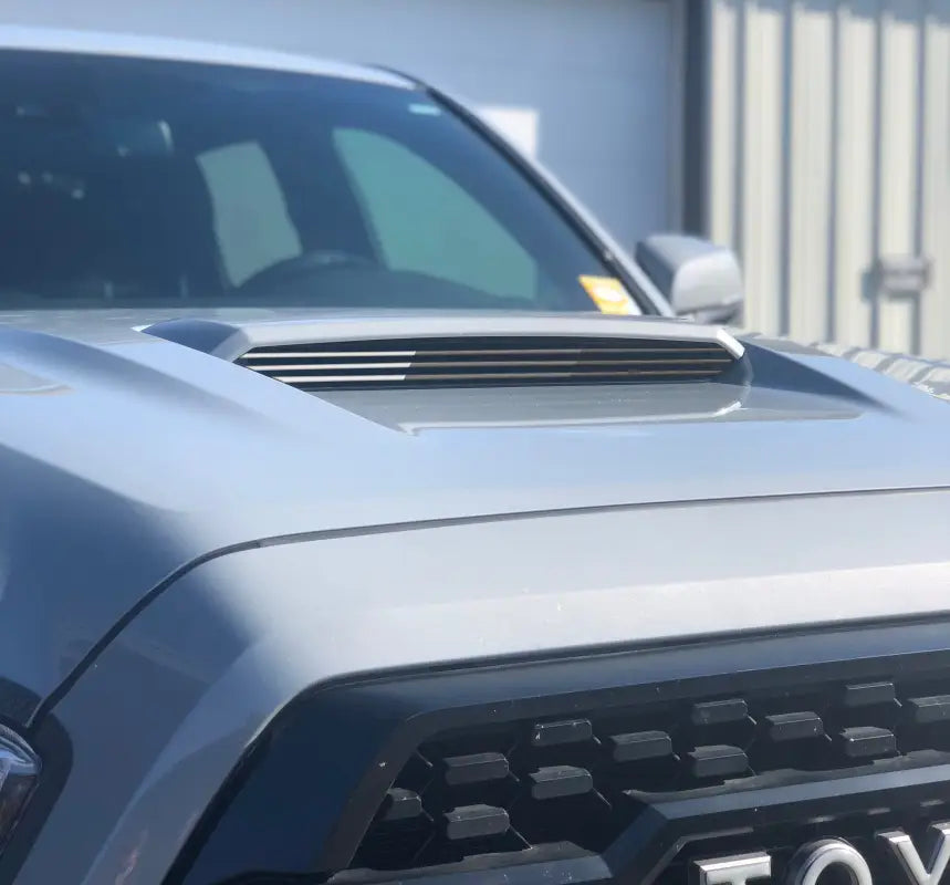 Black inner hood scoop line accents installed on a Toyota Tacoma, providing a subtle and refined exterior upgrade.