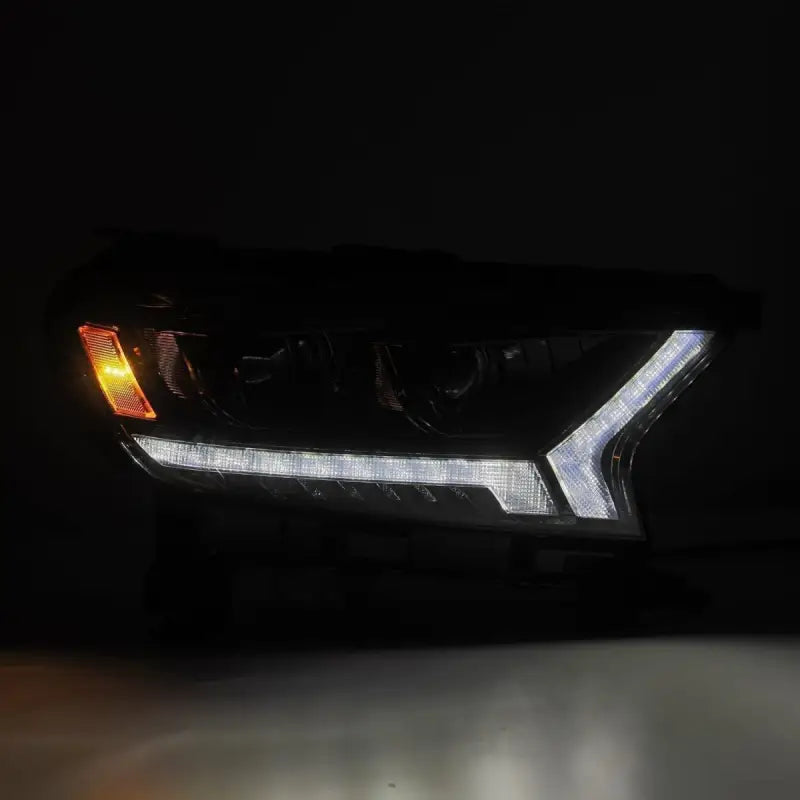 Ford Ranger 19-22 LUXX-Series LED projector headlight illuminated with white LED DRL and amber turn signal in a dark setting.