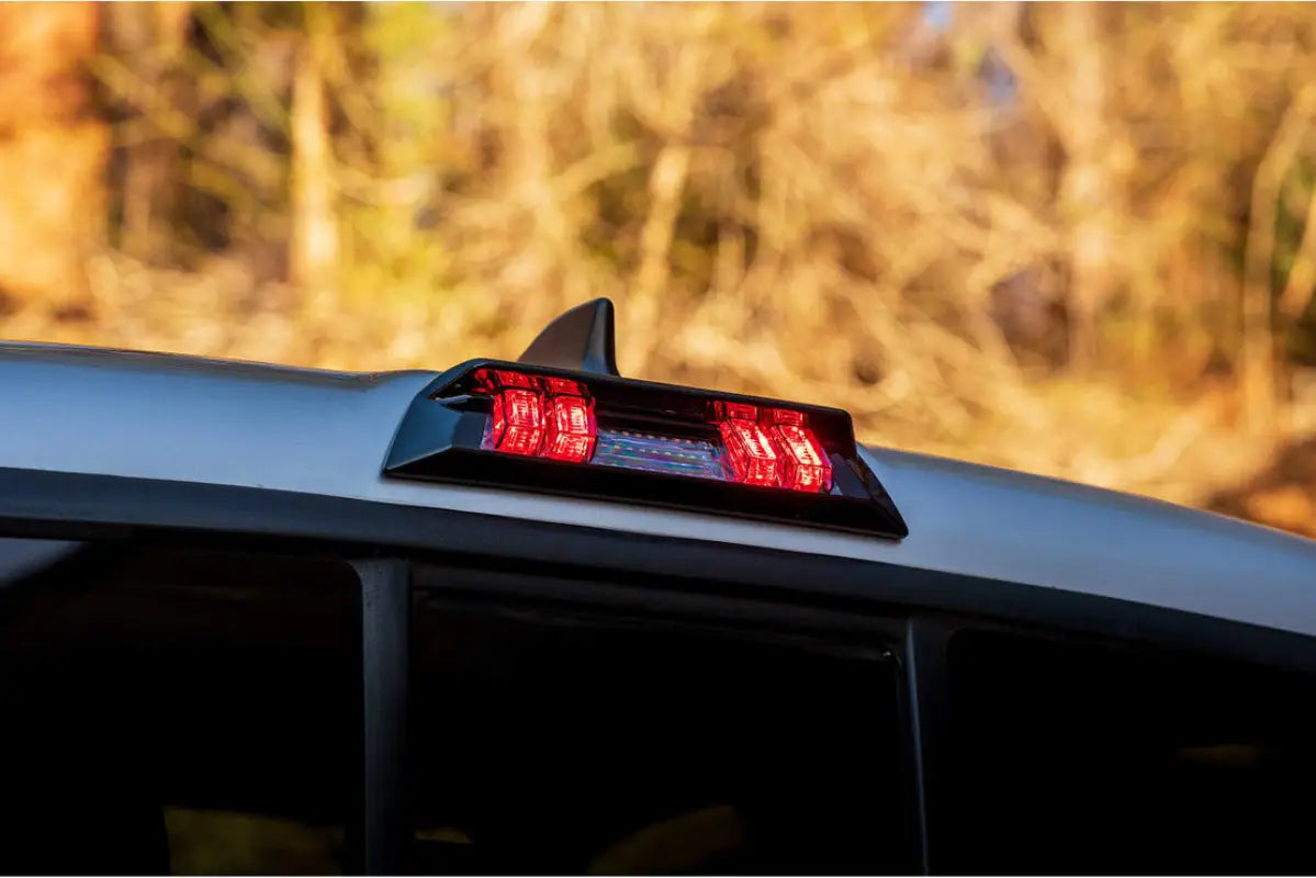 Morimoto X3B LED third brake light installed on a Tacoma (2016-2023) Double Cab, illuminated in red during evening.