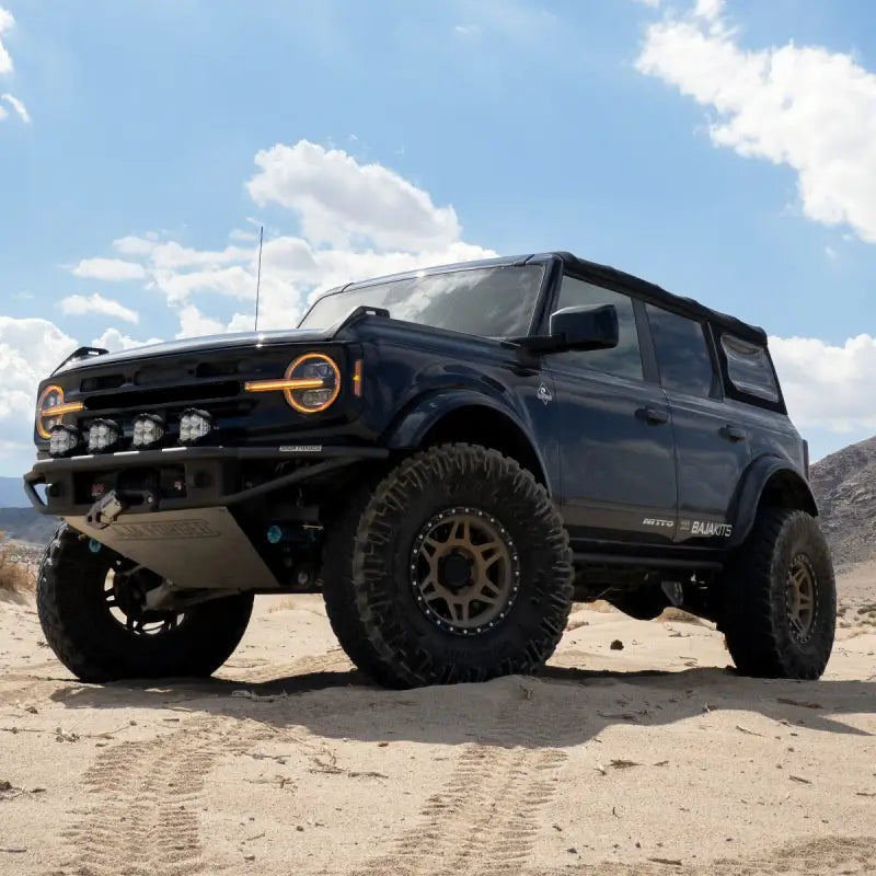 Ford Bronco equipped with NOVA-Series LED projector headlights, parked on a sandy terrain with off-road modifications.