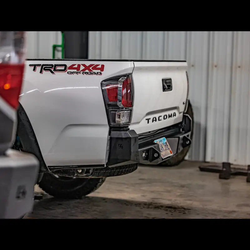 High clearance Tacoma Overland Rear Bumper for 2016+ models, featuring bolt-on installation and steel construction, mounted on a white Tacoma.