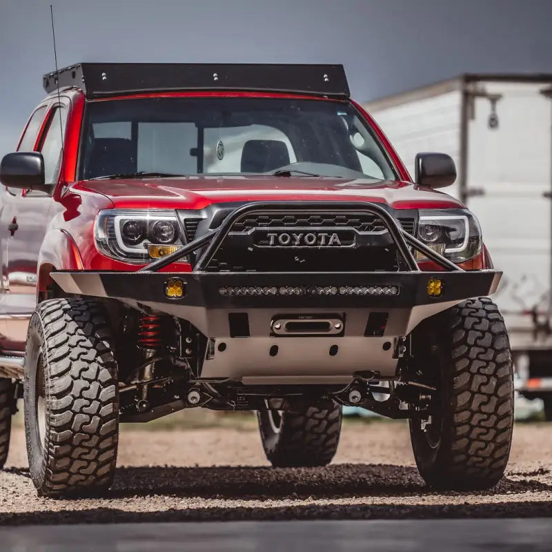 Red 2nd Gen Toyota Tacoma equipped with Tacoma Overland Series front bumper, showcasing enhanced tire clearance and winch compatibility.