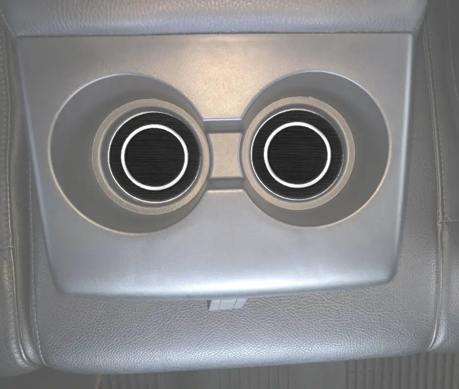 Rear seat cup holder inserts installed in a 2007-2021 Toyota Tundra, featuring a sleek black foam design with white circular accents.
