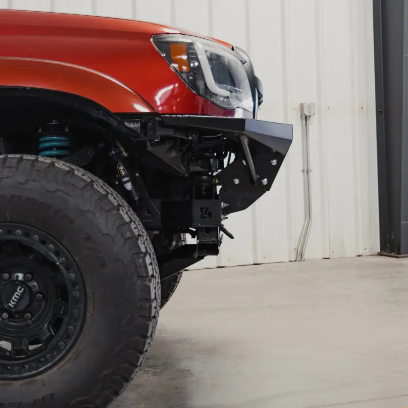 Close-up side view of the Tacoma Rock Runner bumper installation highlighting the modular design and bolt-on wings.