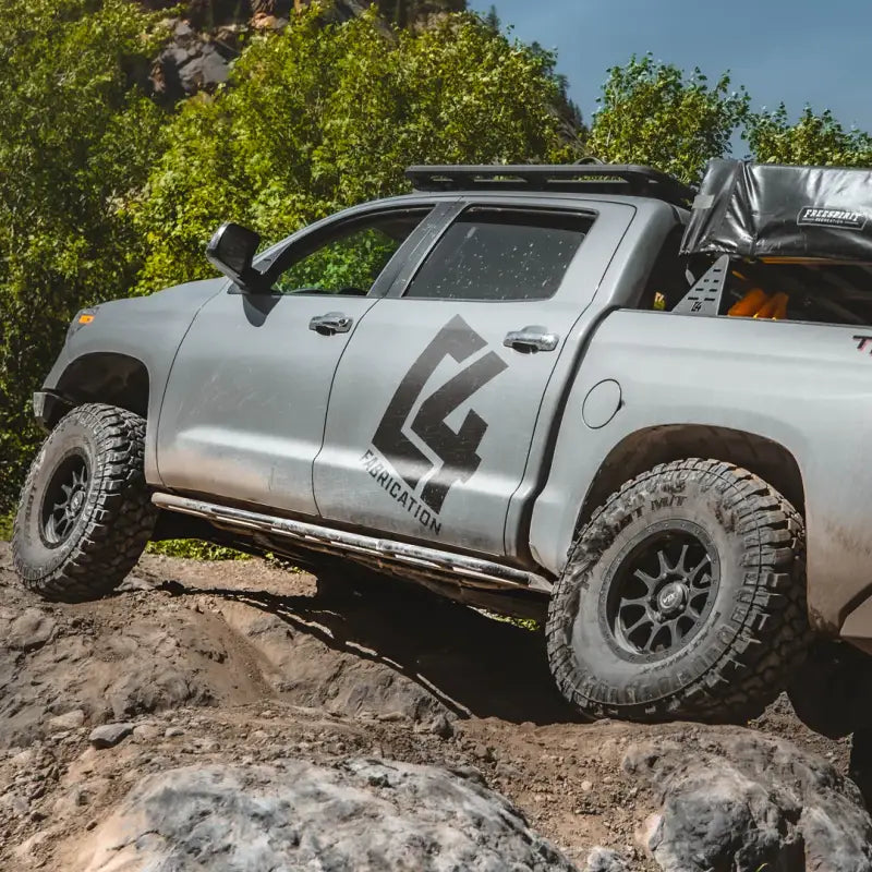2014-2021 Tundra with 2nd Gen rock sliders on rugged terrain, showcasing bolt-on design and rocker panel protection.