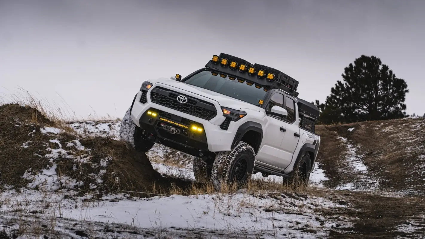 White Toyota Tacoma off-roading with RS7-H Hybrid MonoForged Wheel in Matte Bronze featuring lug nuts
