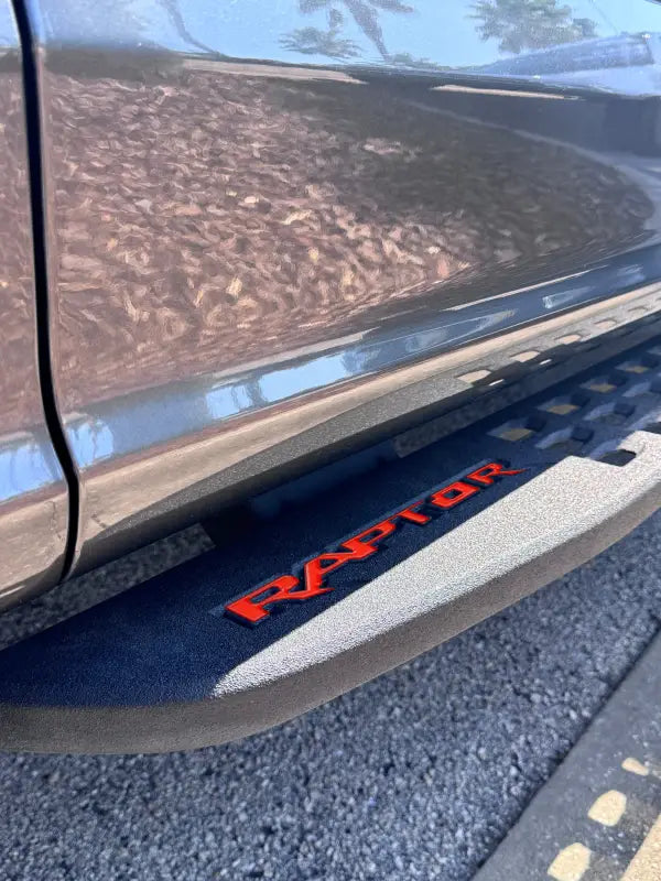 Red RAPTOR lettering running board emblem overlays for Ford Raptor running board