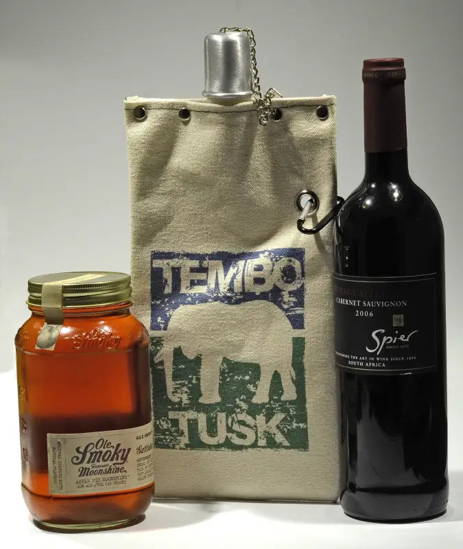 TemboTusk Wine Tote holding a 750ml wine bottle, displayed with a jar of Ole Smoky Moonshine, showcasing its beverage carrying versatility.