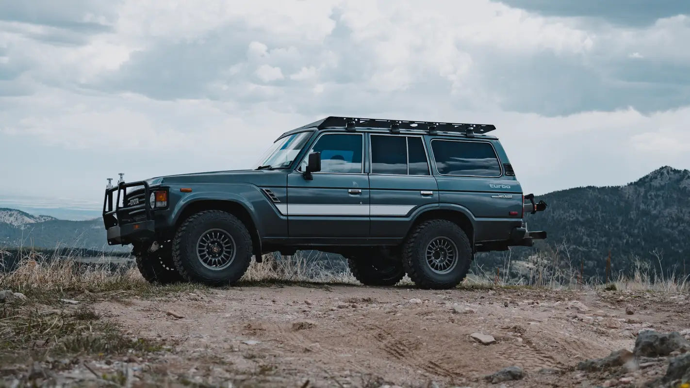 Side profile of a Toyota Land Cruiser 60 Series with a heavy-duty roof rack, built for durability and off-road gear storage.