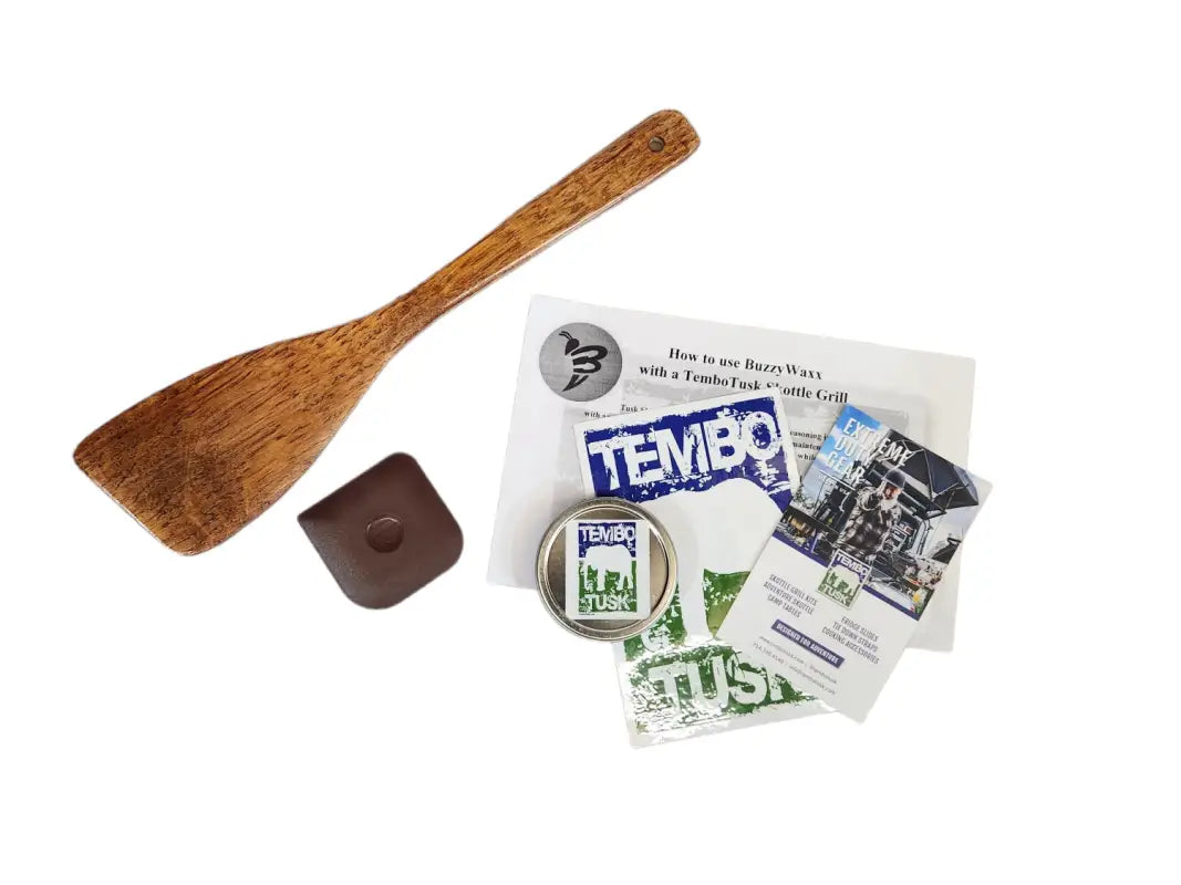 TemboTusk Skottle Grill kit extras including a wooden spatula, wax, stickers, and user guide for easy outdoor cooking.