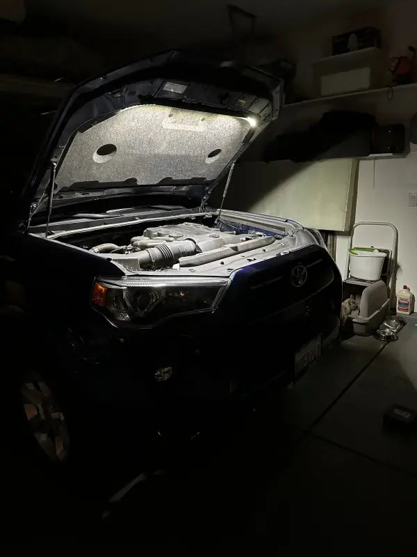 Toyota 4Runner engine bay illuminated by the under hood LED light kit in a garage, highlighting its bright and efficient lighting.