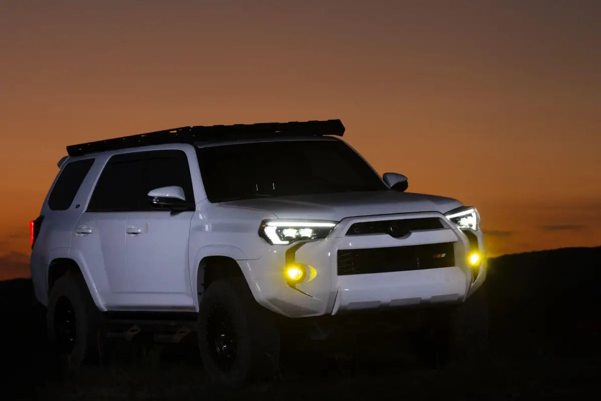 White SUV with roof rack and auxiliary lights featuring XB Evo Hybrid Headlights