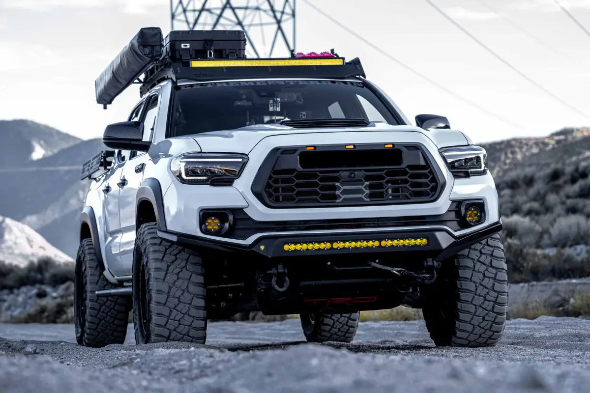 White Toyota Tacoma off-road truck with XB Evo Hybrid Headlights on rugged terrain
